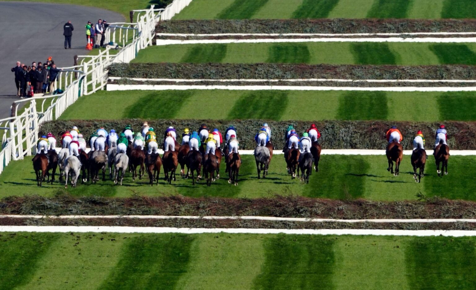The Grand National field seen from above as the horses gallop between the spruce fences at Aintree