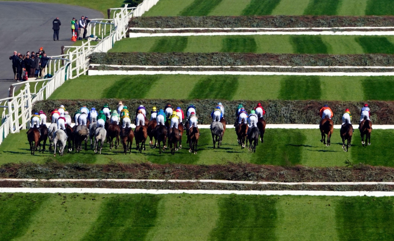The Grand National field seen from above as the horses gallop between the spruce fences at Aintree