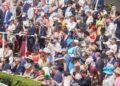 Racegoers in hats and morning dress packed into the stands at Royal Ascot