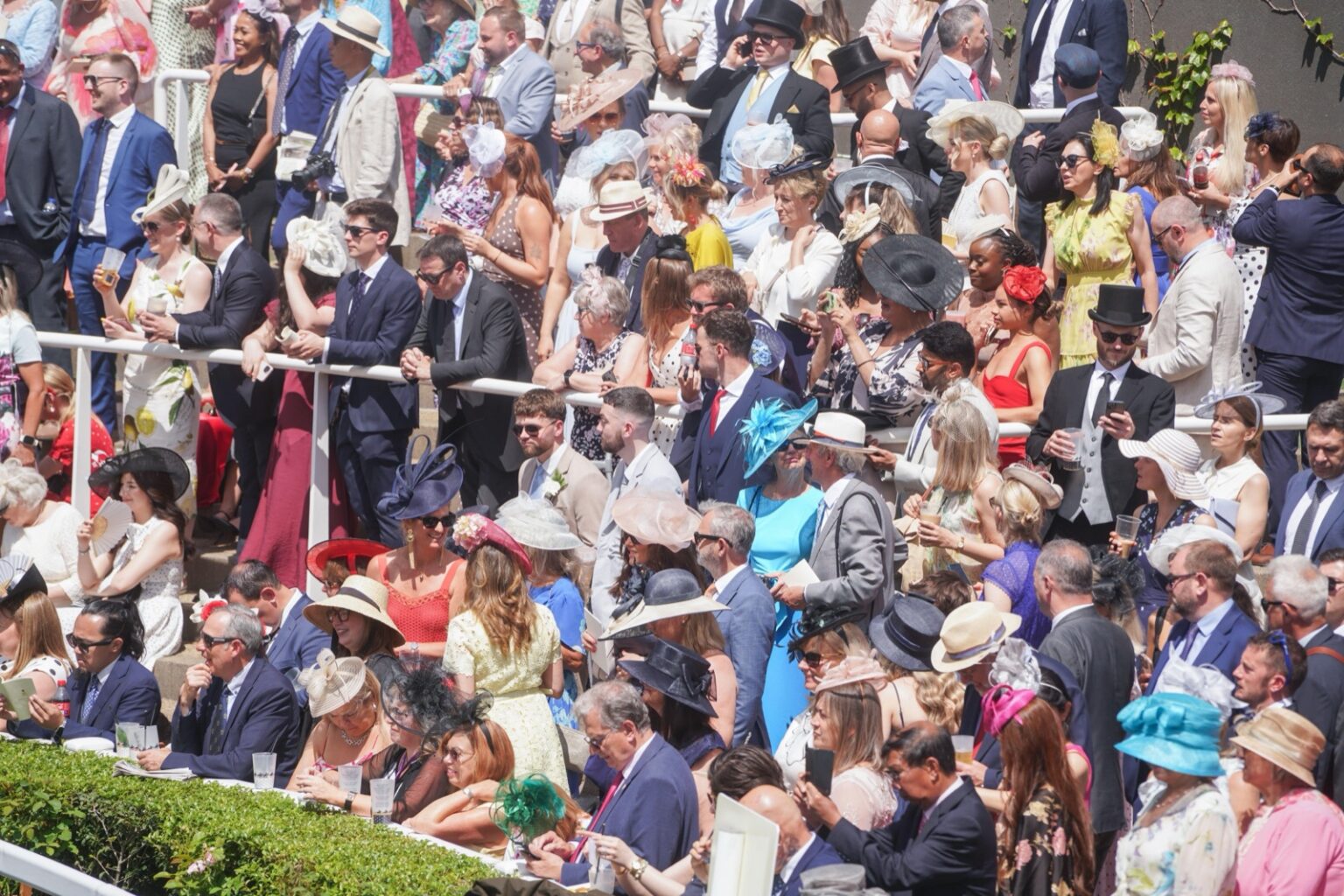 Racegoers in hats and morning dress packed into the stands at Royal Ascot