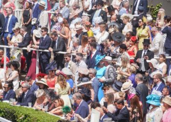 Racegoers in hats and morning dress packed into the stands at Royal Ascot
