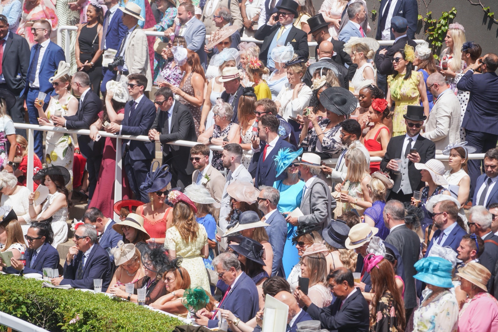 Racegoers in hats and morning dress packed into the stands at Royal Ascot